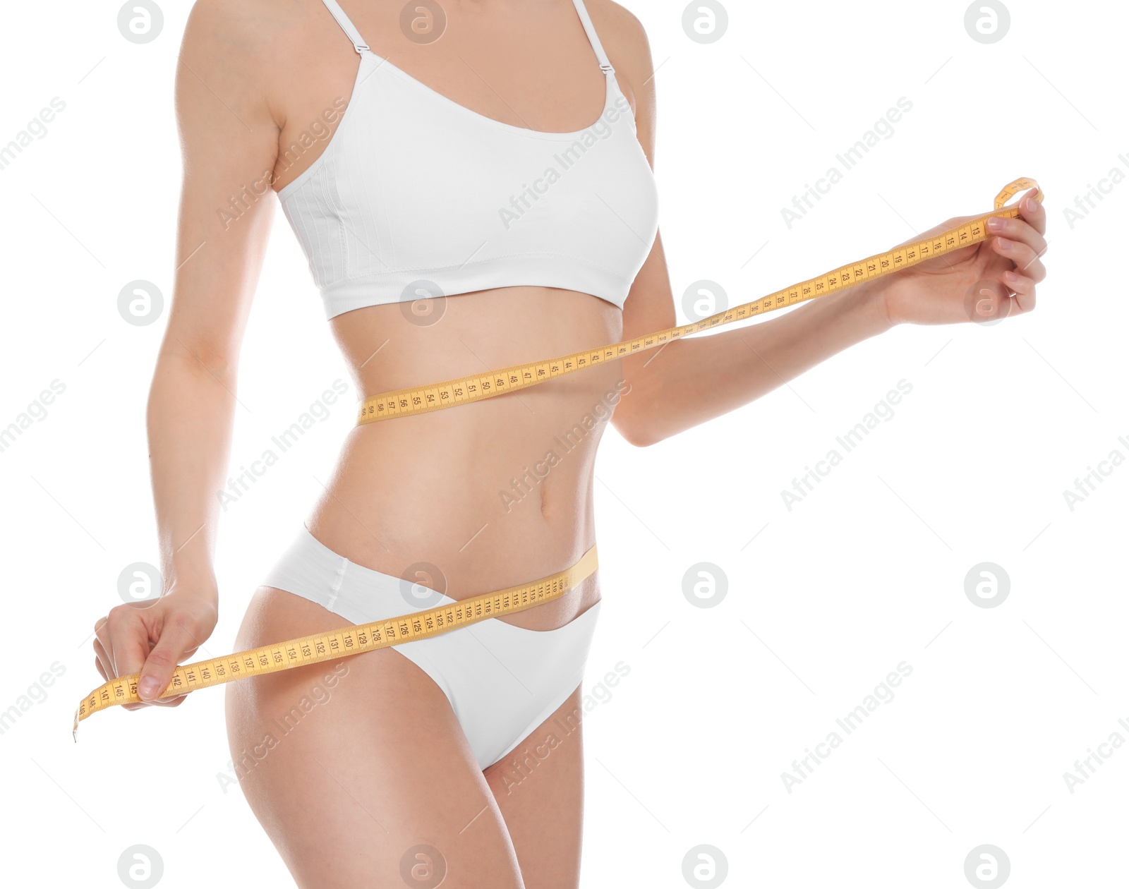 Photo of Slim young woman with smooth gentle skin in underwear measuring body on white background