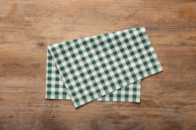 Checkered tablecloth on wooden table, top view
