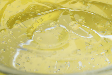 Pure transparent cosmetic gel on yellow background, closeup