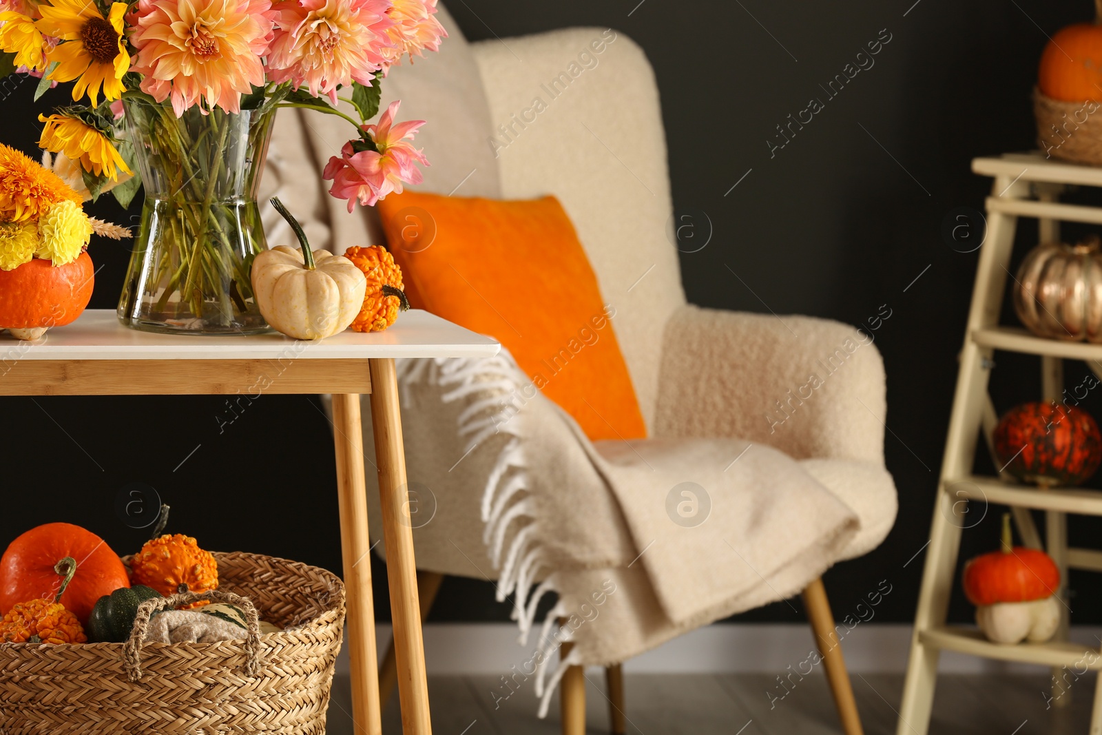 Photo of Room decorated with pumpkins and bright flowers, space for text. Autumn vibes