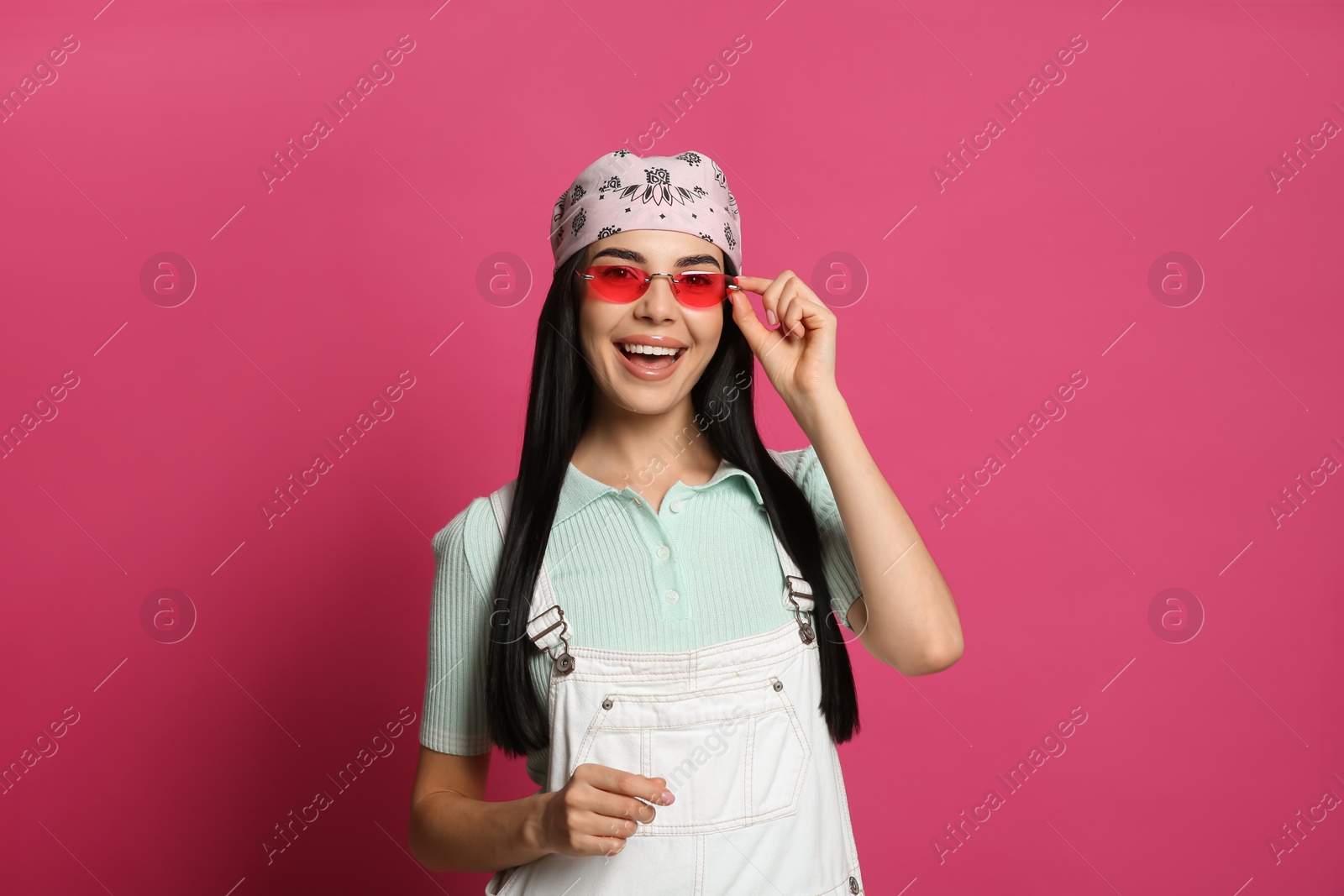 Photo of Young woman wearing stylish bandana and sunglasses on pink background