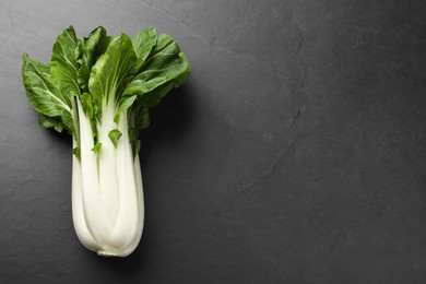 Fresh green pak choy cabbage on black table, top view. Space for text