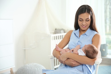 Young woman with her newborn baby at home. Space for text