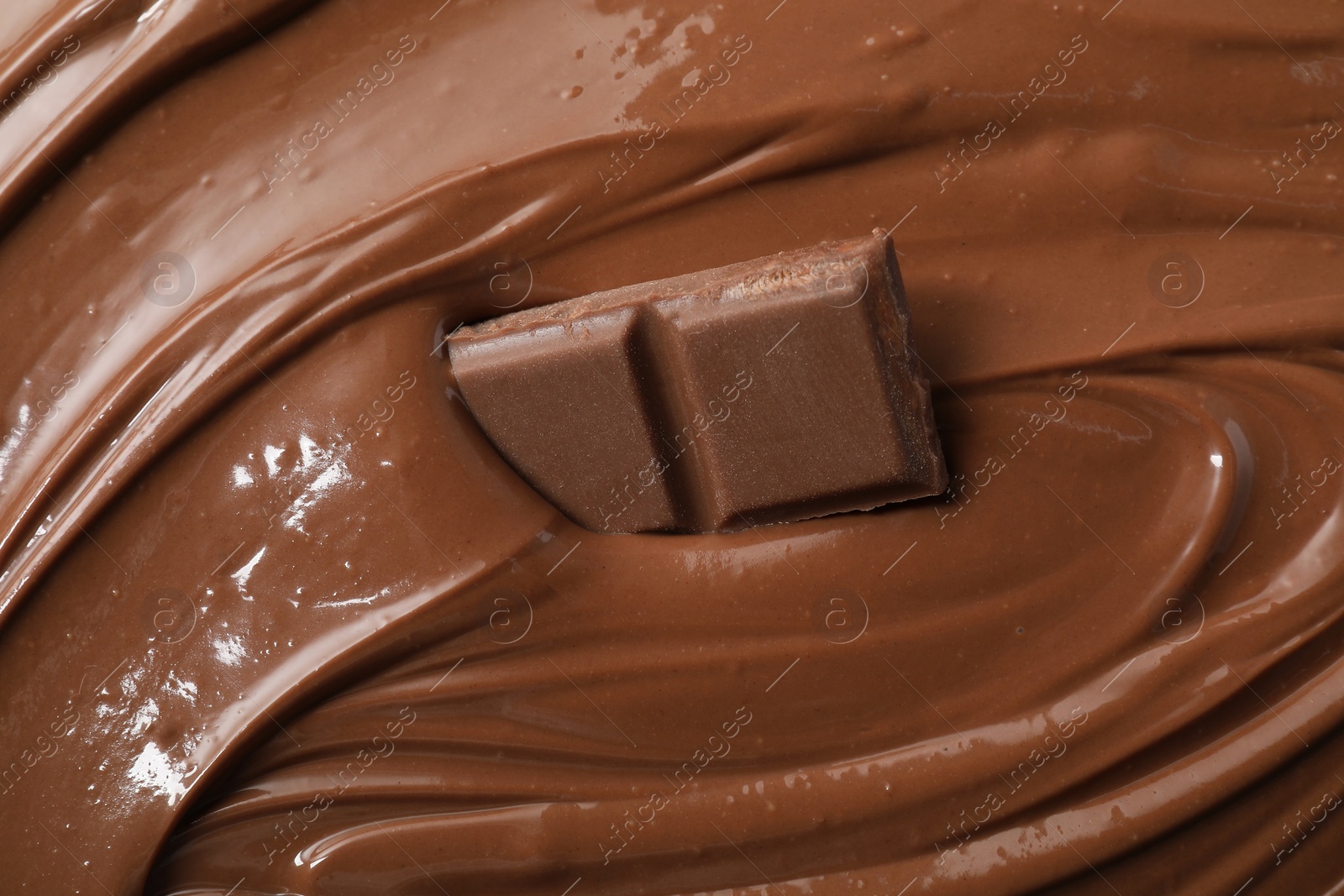 Photo of Tasty milk chocolate paste and pieces as background, closeup