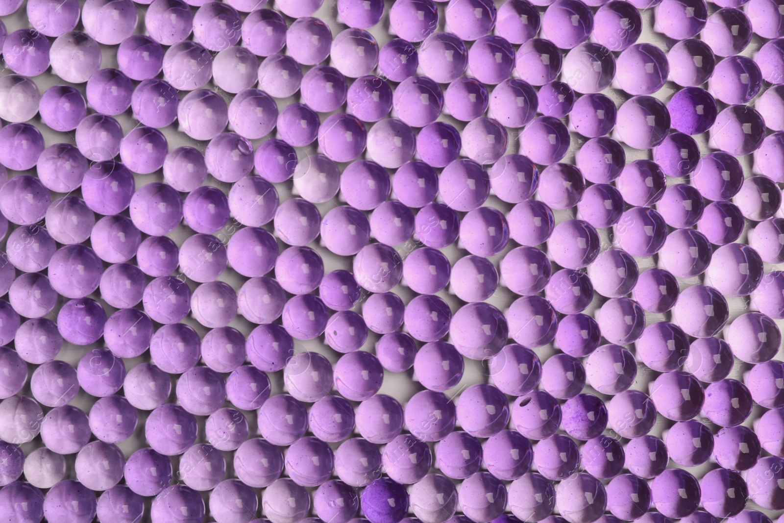 Photo of Top view of violet vase filler as background. Water beads