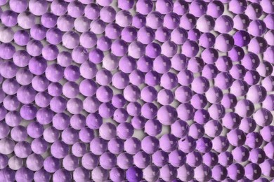Top view of violet vase filler as background. Water beads