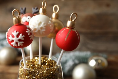 Delicious Christmas ball cake pops on blurred background, closeup