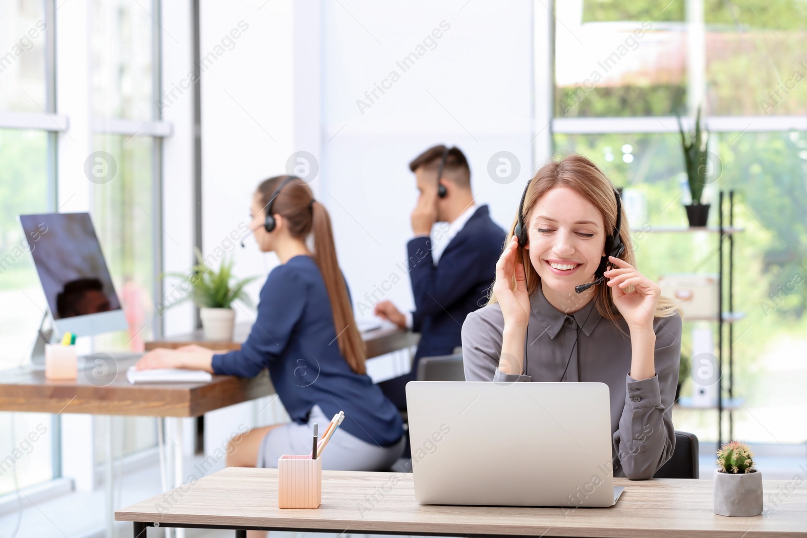 Photo of Female receptionist with headset at desk in office