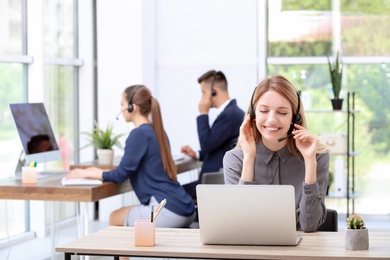 Photo of Female receptionist with headset at desk in office