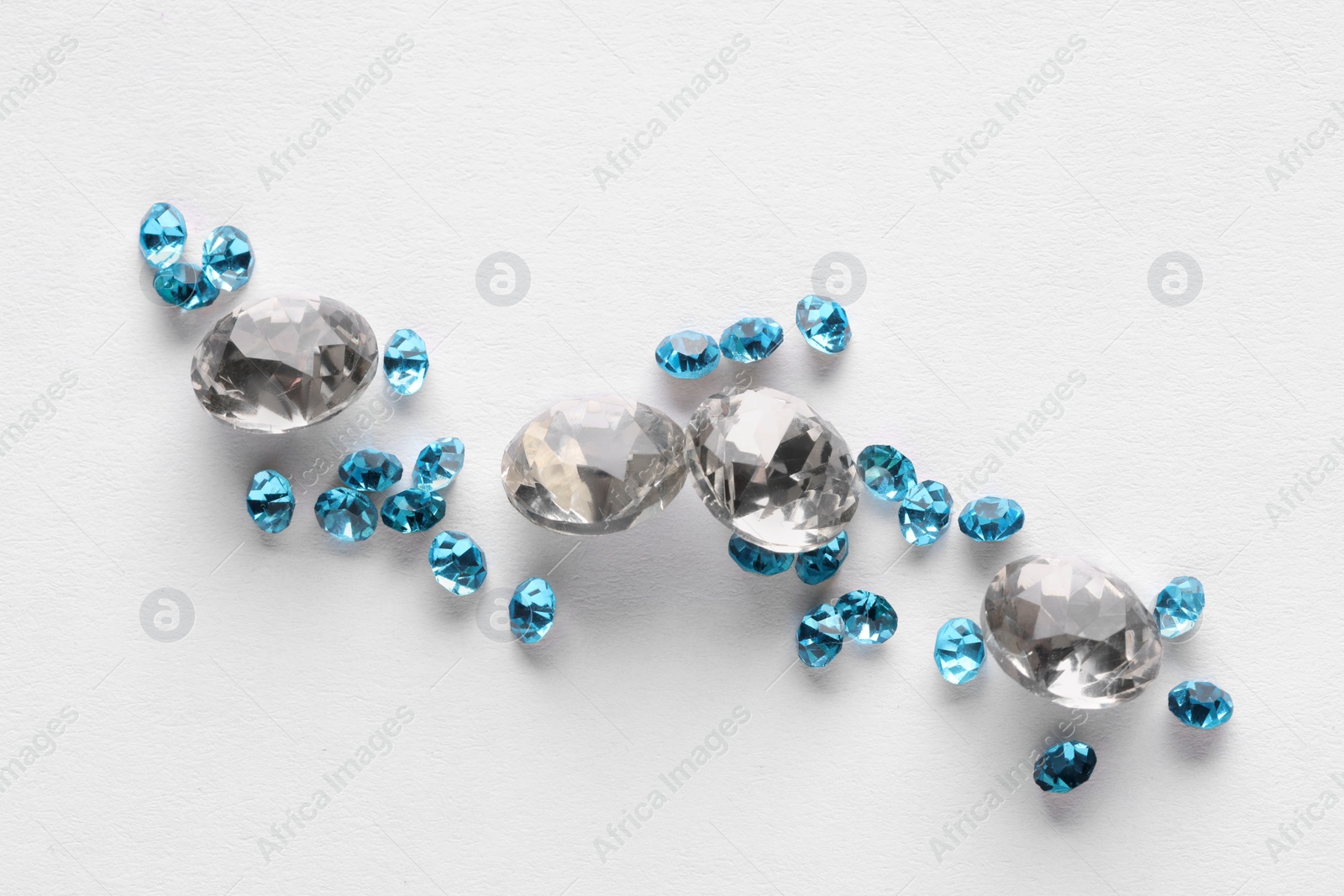 Photo of Different beautiful gemstones for jewelry on white background, top view