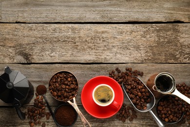 Coffee maker, beans, powder and cup of drink on wooden table, flat lay. Space for text