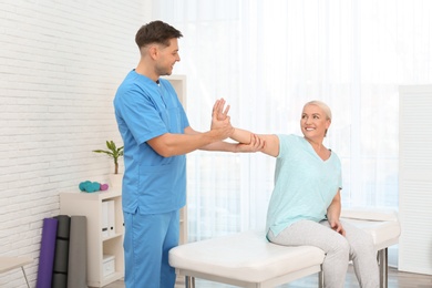 Photo of Physiotherapist working with patient in clinic. Rehabilitation therapy