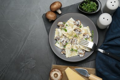 Photo of Delicious ravioli with ingredients on black table, flat lay. Space for text