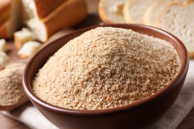 Photo of Fresh bread crumbs in bowl on table, closeup