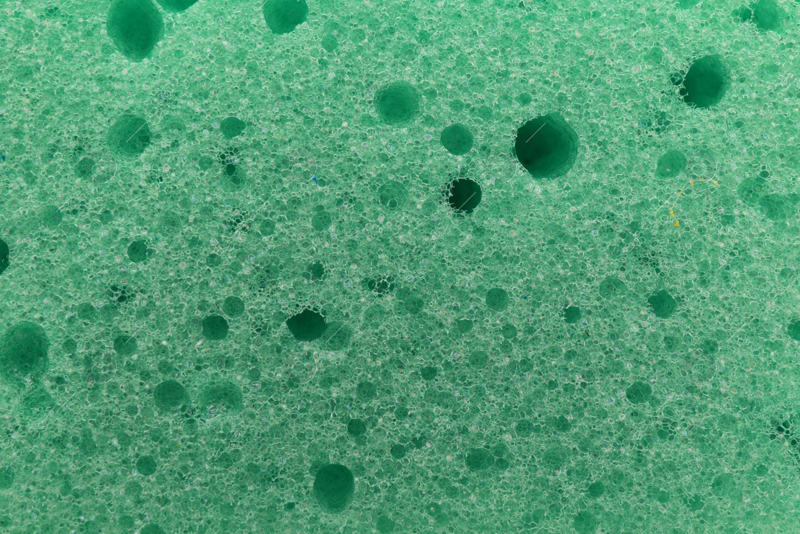 Photo of Green cleaning sponge as background, top view