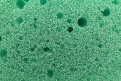 Green cleaning sponge as background, top view