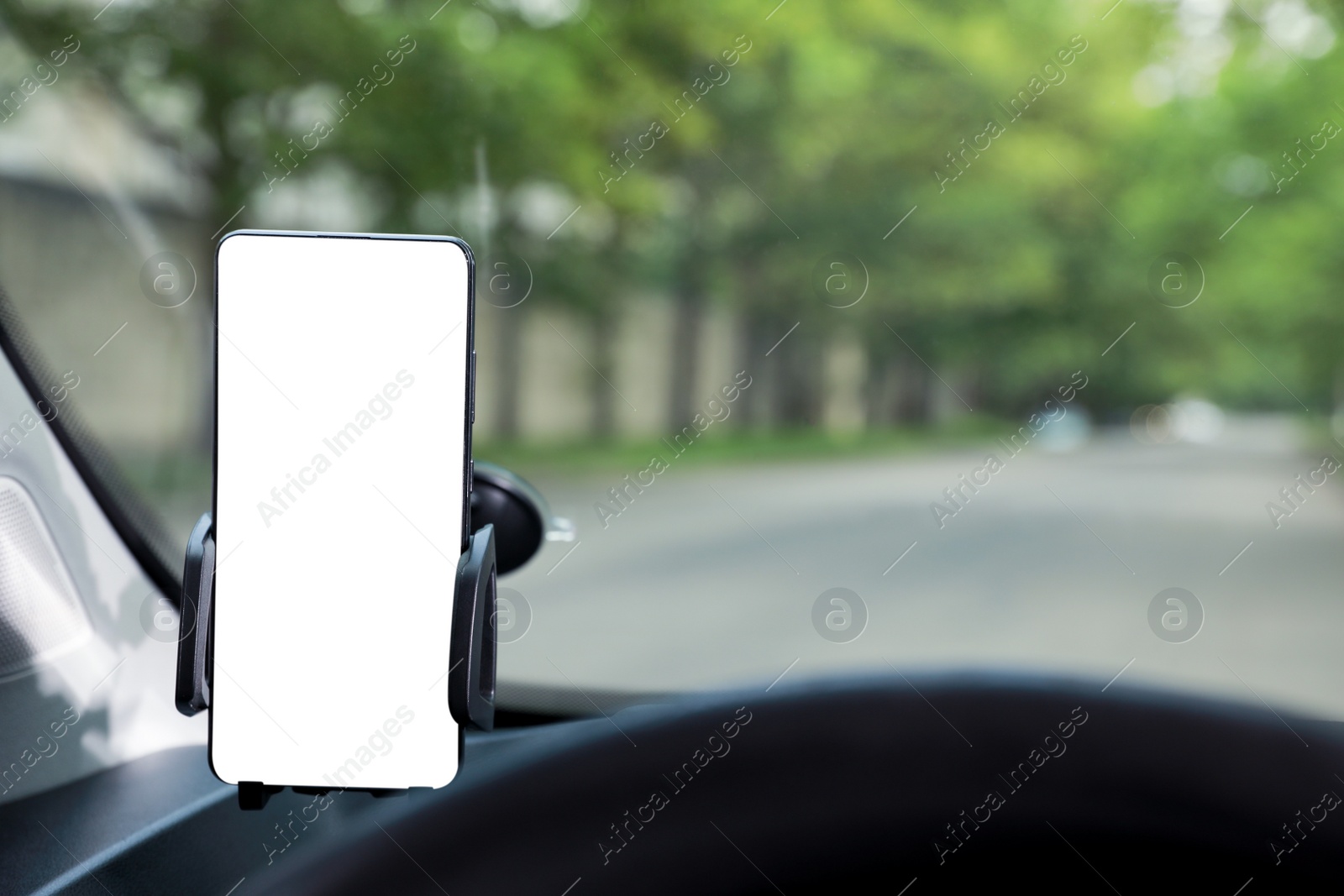 Photo of Car holder with modern mobile phone on windshield of automobile. Mockup for design