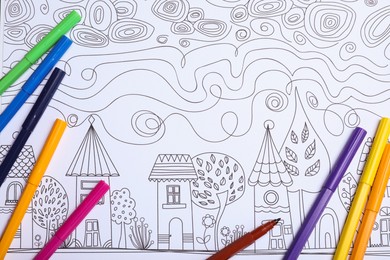 Photo of Felt tip pens on antistress coloring page, top view