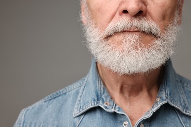 Photo of Man with mustache on grey background, closeup. Space for text