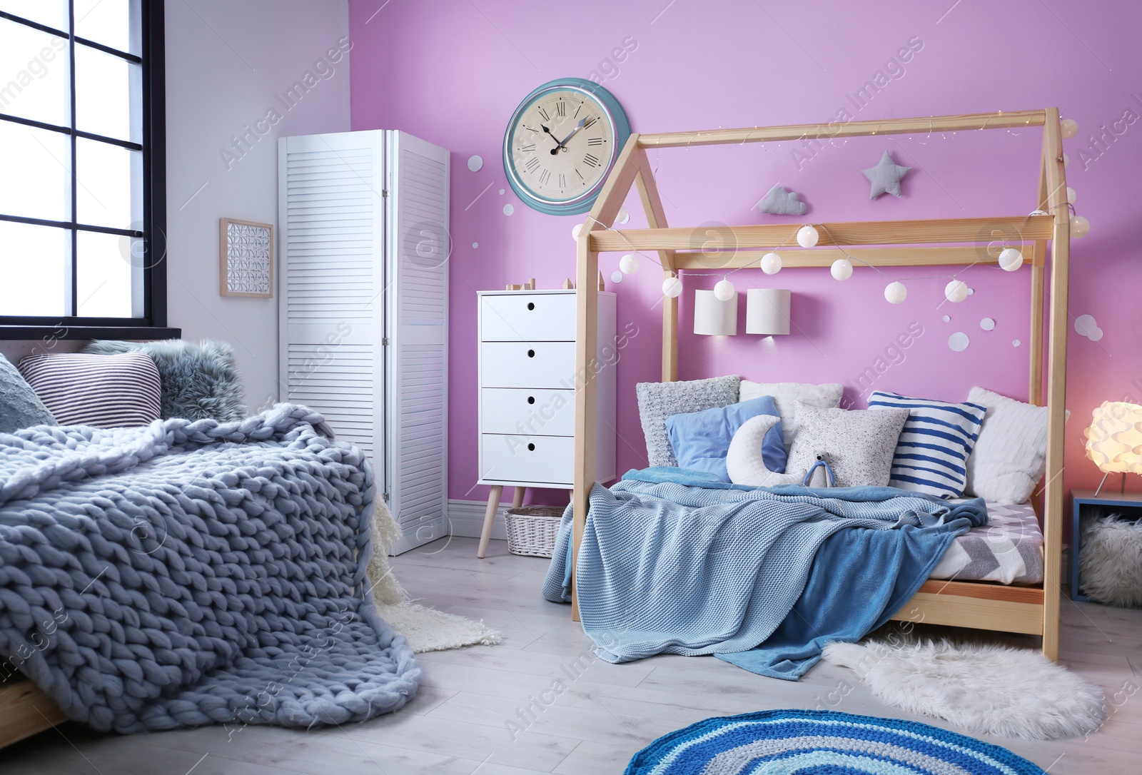 Photo of Child's room interior with comfortable bed and garland