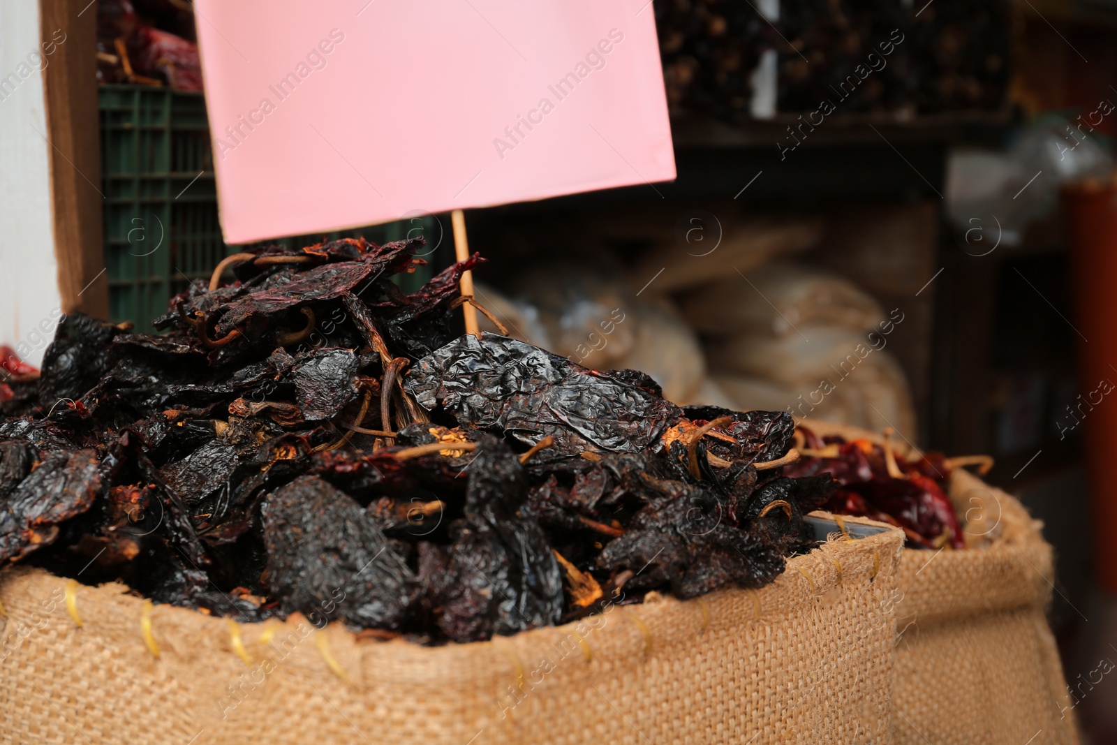 Photo of Pile of dried black ancho chiles in burlap, closeup