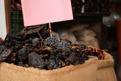 Pile of dried black ancho chiles in burlap, closeup