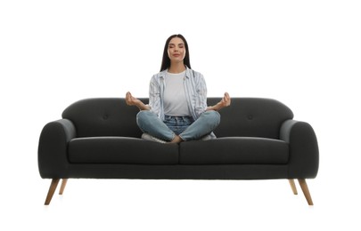 Young woman meditating on comfortable grey sofa against white background