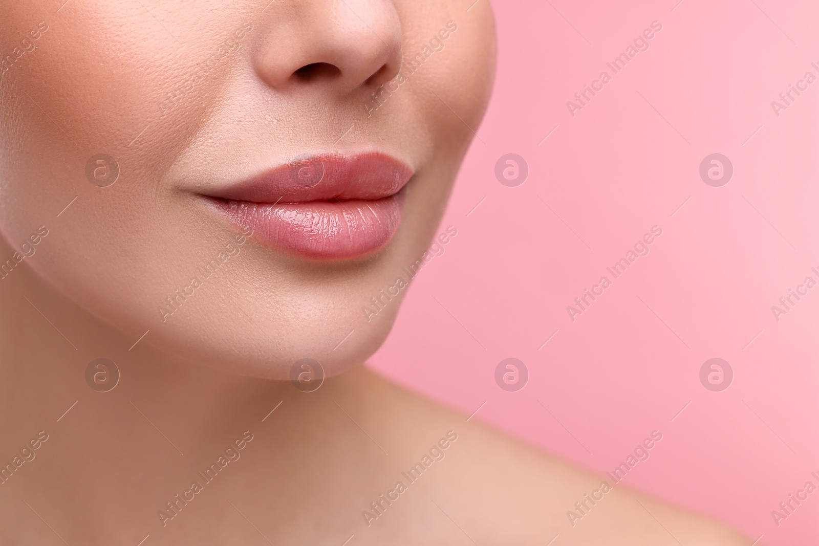 Photo of Woman with beautiful lips on pink background, closeup. Space for text