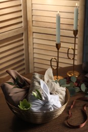 Photo of Furoshiki technique. Gifts packed in different fabrics, flowers and ribbon on wooden table