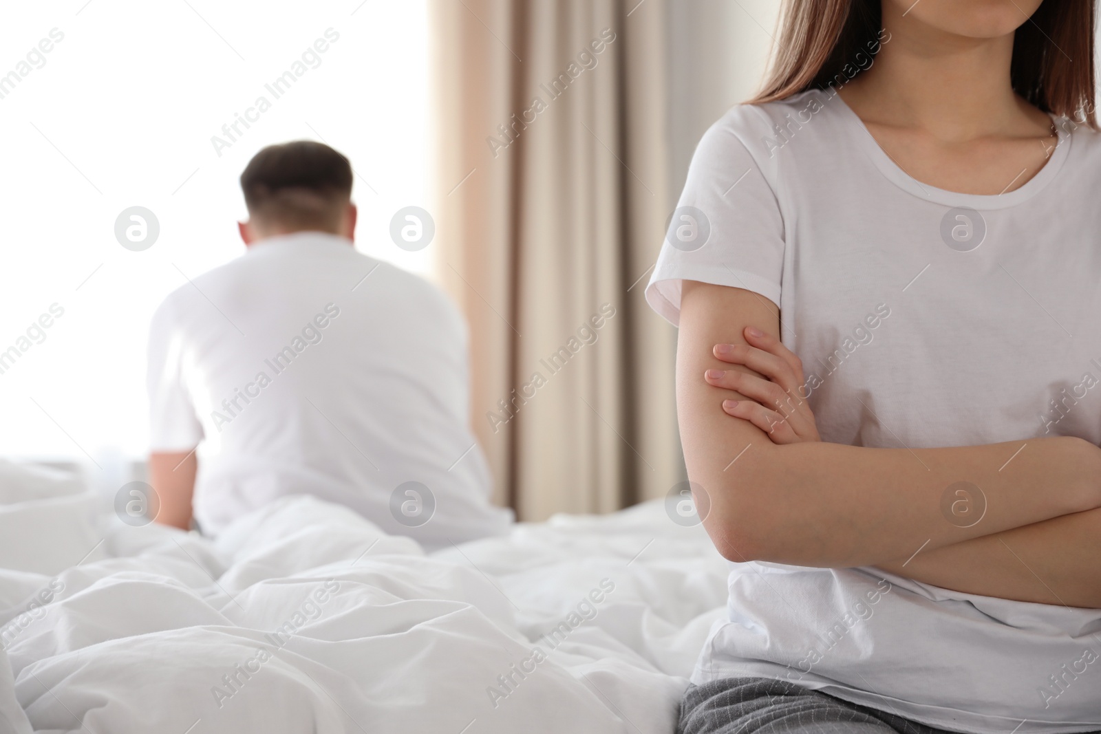 Photo of Unhappy couple with problems in relationship on bed at home, closeup