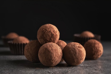 Photo of Tasty raw chocolate truffles on grey table