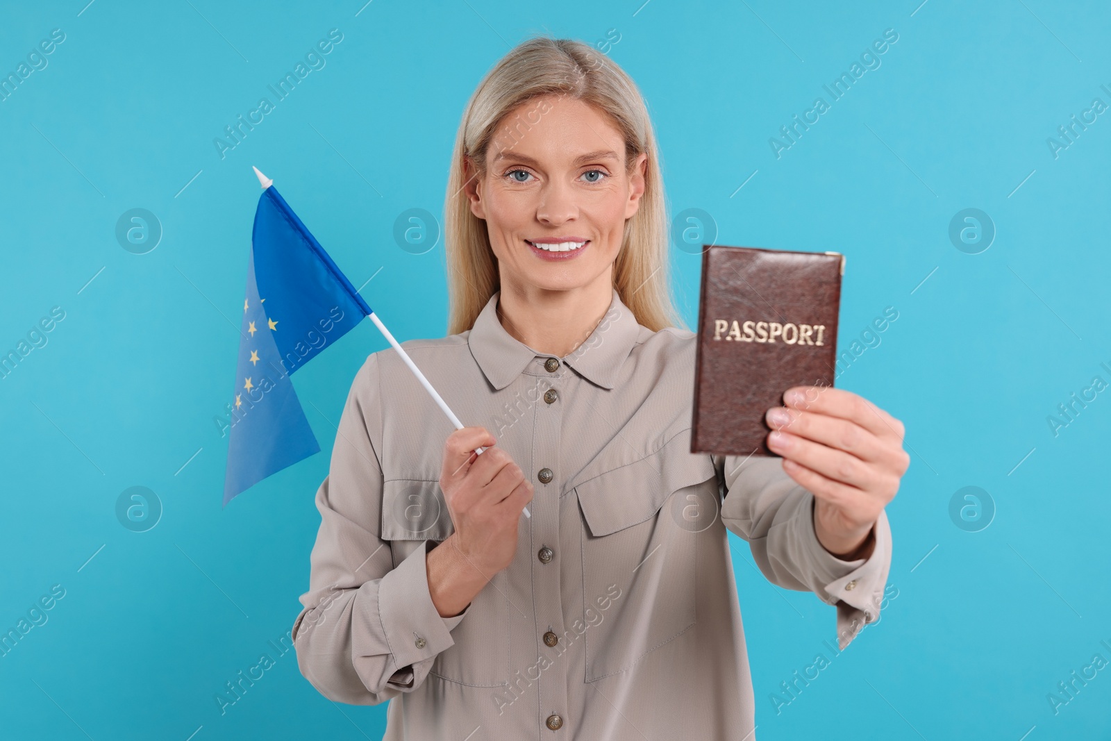 Photo of Immigration. Happy woman with passport and flag of European Union on light blue background