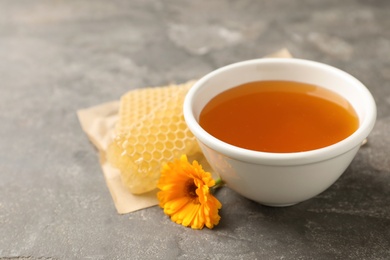 Photo of Composition with bowl of tasty fresh honey on table