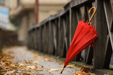 Photo of Autumn atmosphere. One red umbrella on city street, space for text