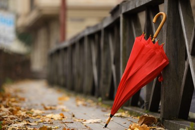 Autumn atmosphere. One red umbrella on city street, space for text