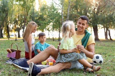 Happy family having picnic in park on sunny day