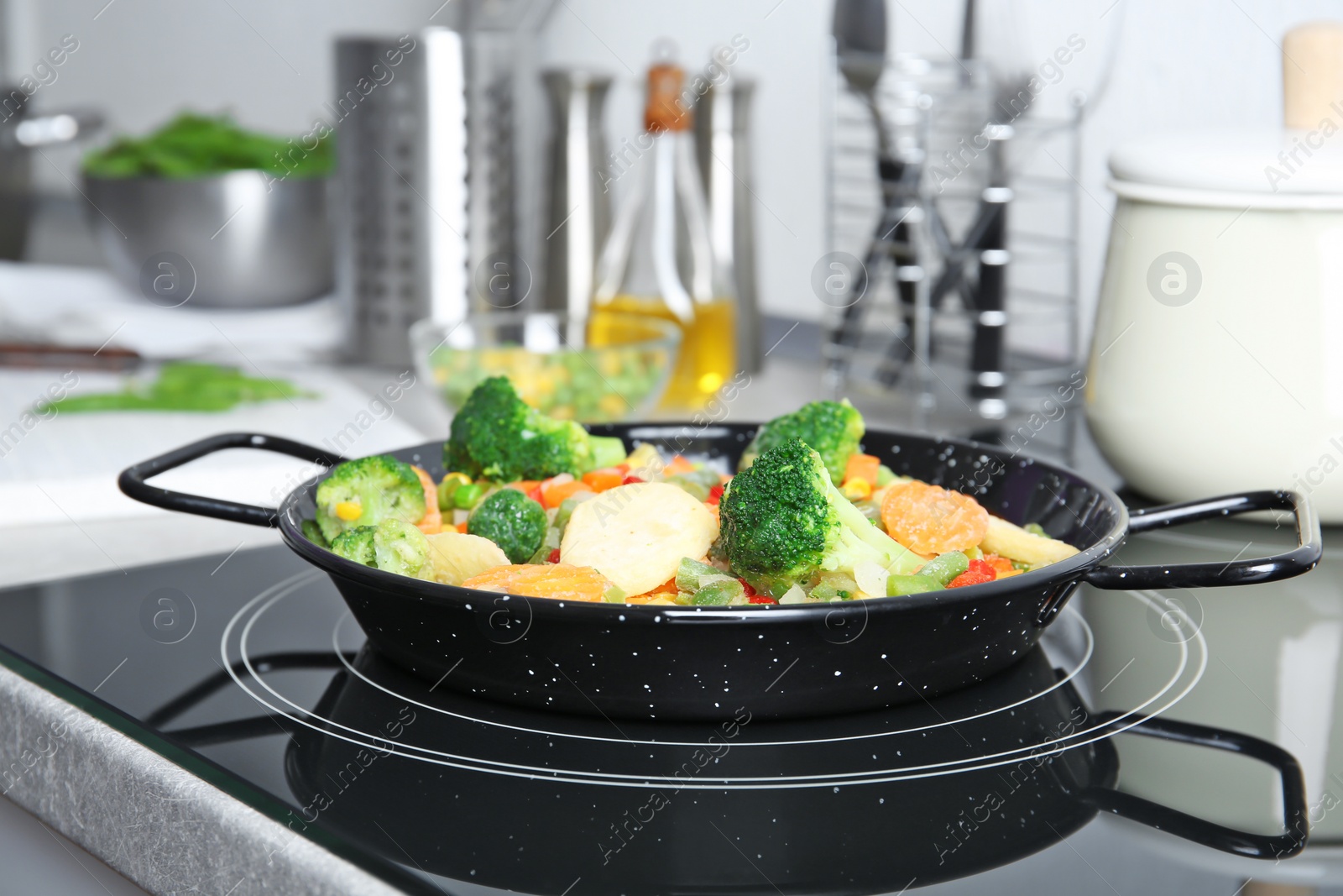 Photo of Frying pan with frozen vegetables on electric stove