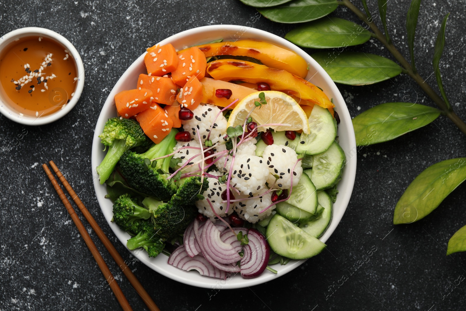 Photo of Bowl with many different vegetables and rice on grey textured table, flat lay. Vegan diet