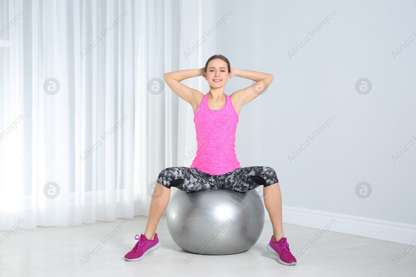 Photo of Young woman doing fitness exercises at home