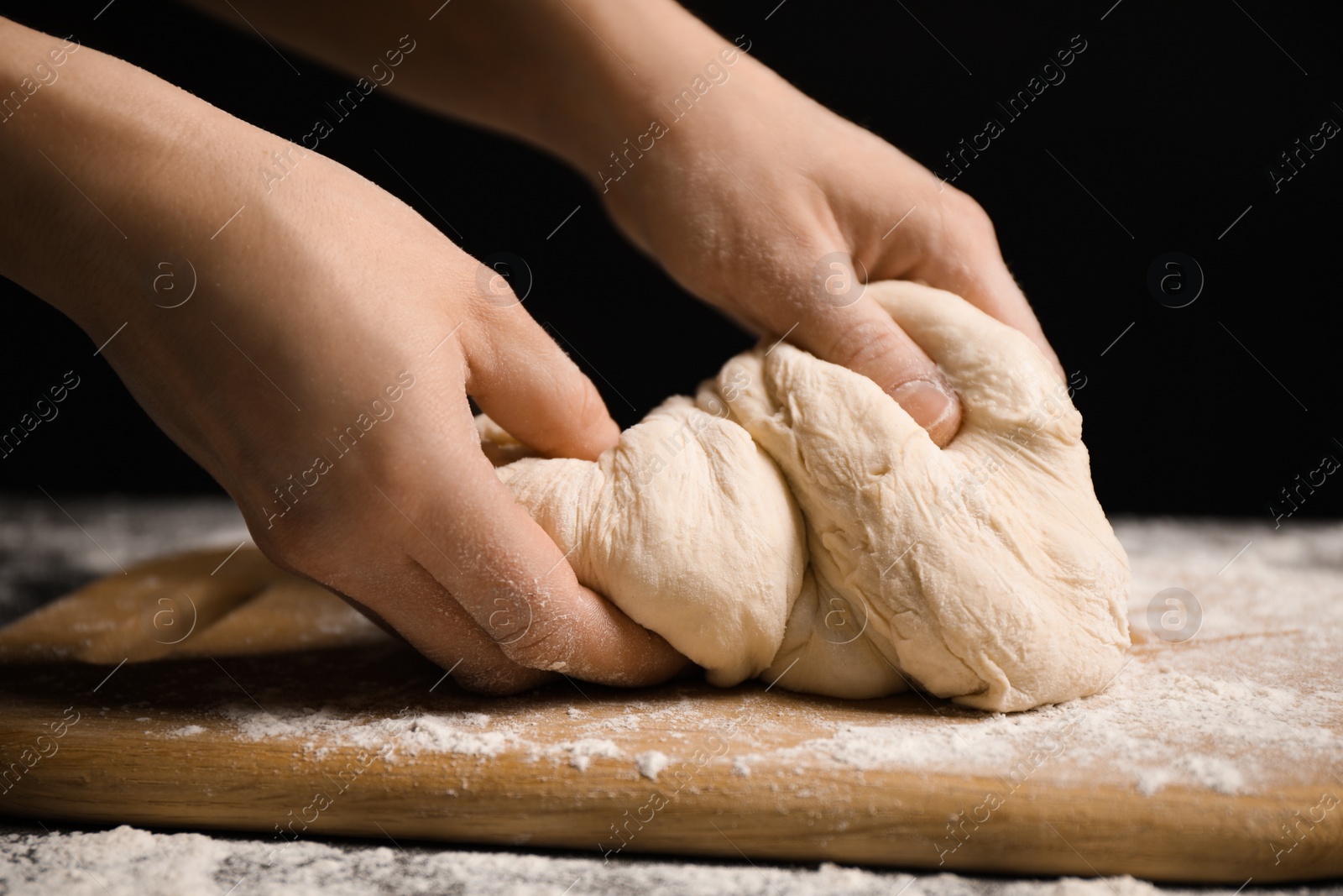 Photo of Woman with dough at grey table, closeup. Making pasta