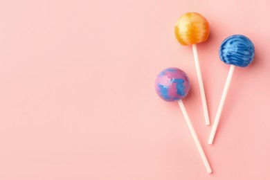 Tasty lollipops on pink background, flat lay. Space for text