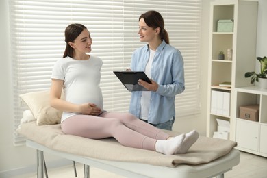 Doula working with pregnant woman indoors. Preparation for child birth