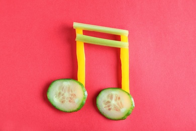 Musical note made of vegetables on color background, top view