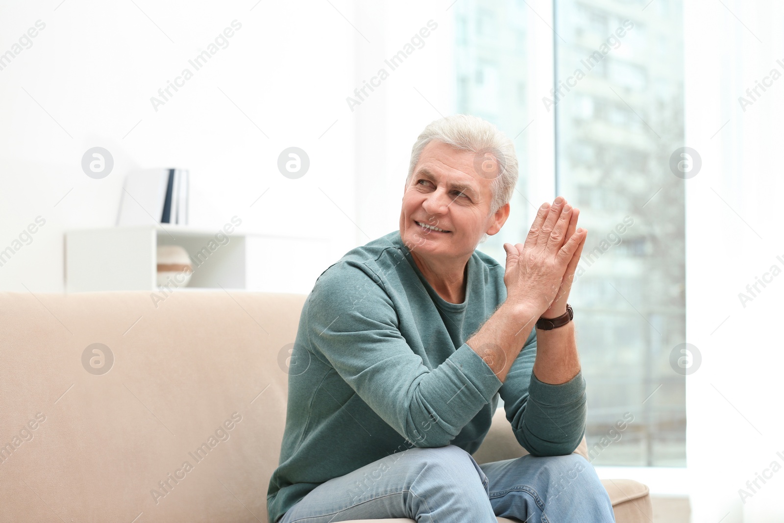 Photo of Portrait of handsome mature man on sofa indoors