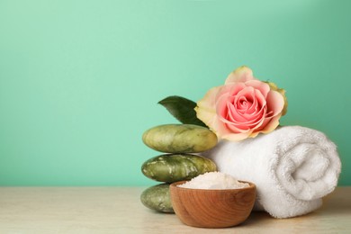 Photo of Composition with different spa products and rose on beige table against turquoise background. Space for text