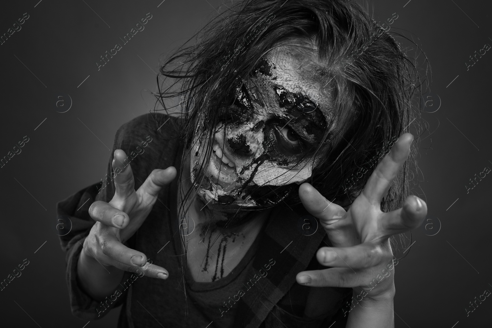 Photo of Scary zombie on dark background, black and white effect. Halloween monster