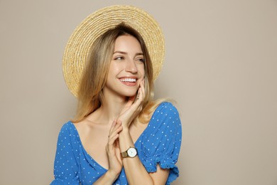 Beautiful young woman wearing straw hat on beige background, space for text. Stylish headdress
