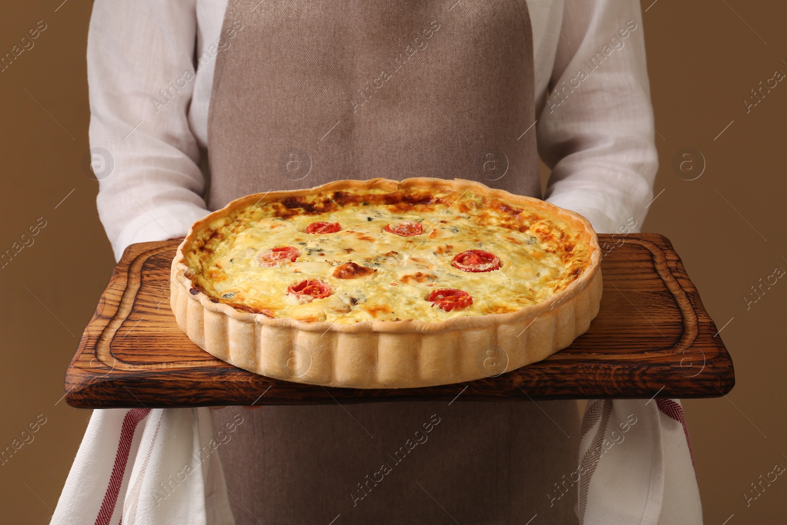 Photo of Woman with delicious homemade cheese quiche on beige background, closeup