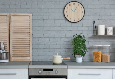 Photo of Modern kitchen interior with new furniture and different utensils