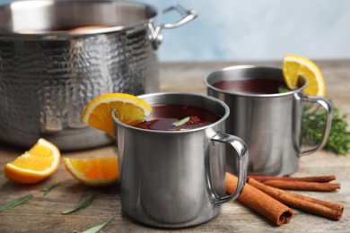 Photo of Tasty mulled wine with spices on wooden table